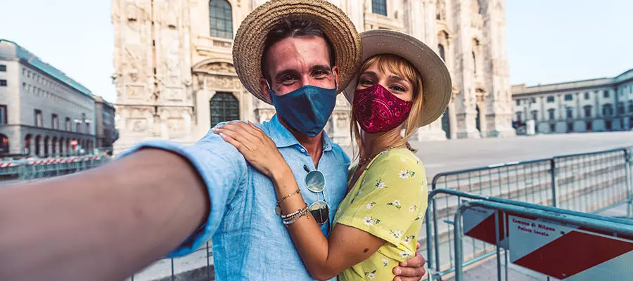 Una pareja tomándose una selfie con una Catedral de fondo.